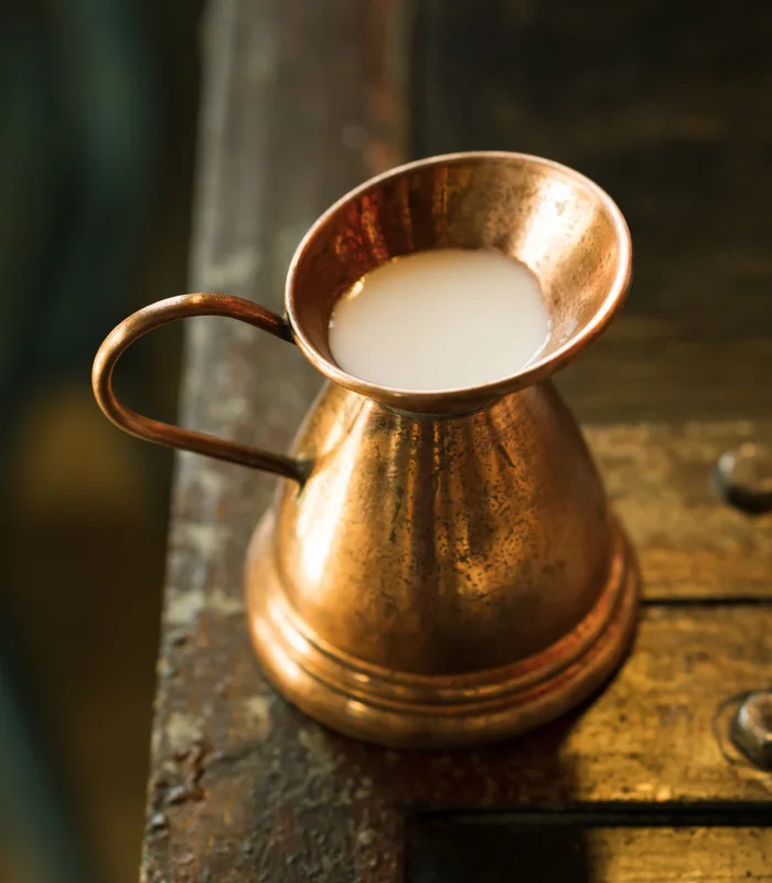 A copper lota filled with fresh milk