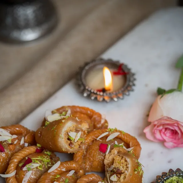 Golden gujiya with a nut filling, garnished with pistachio