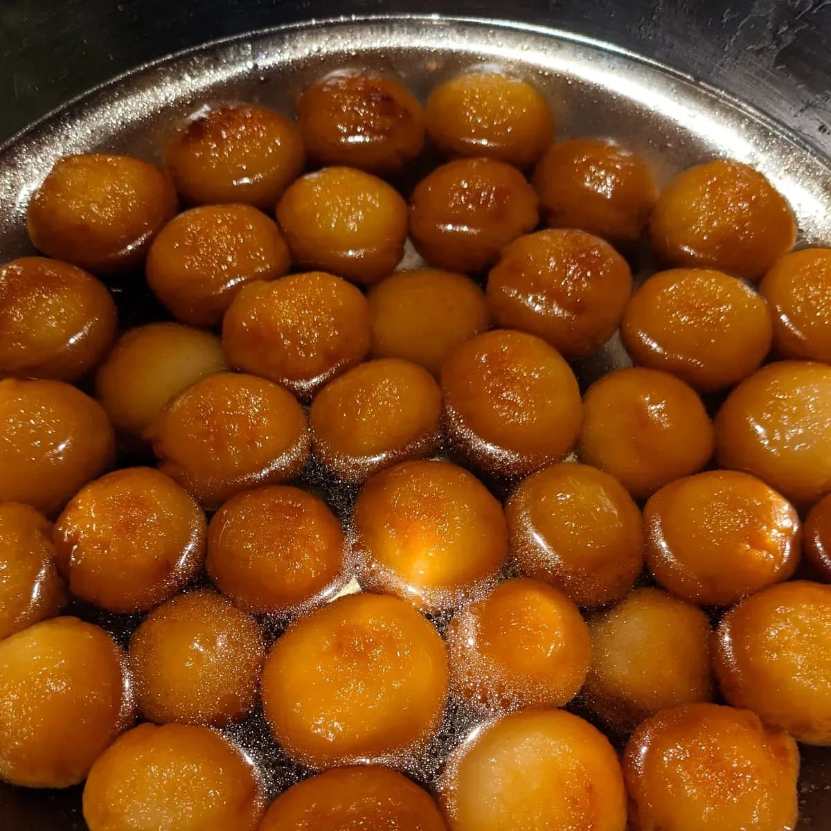 Golden gulab jamun in sugar syrup
