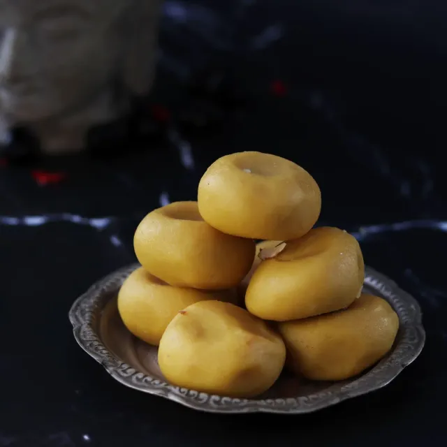 A stack of saffron-yellow kesar peda