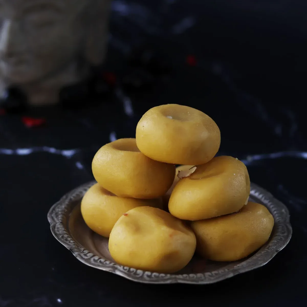 A stack of saffron-yellow kesar peda